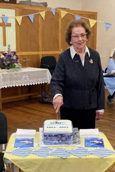 A woman cutting an anniversary cake