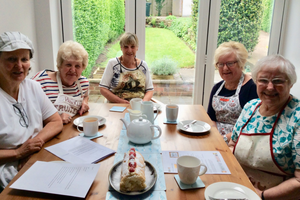 Five women sitting around a table which has a vanilla log in the centre
