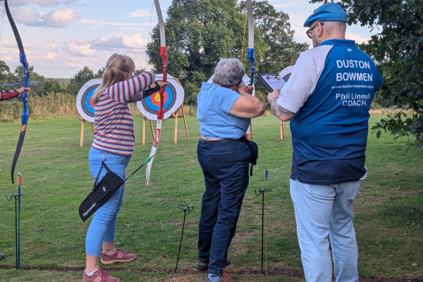 Two u3a members pointing at a dart board