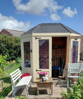 a garden shed in an allotment with benches out front