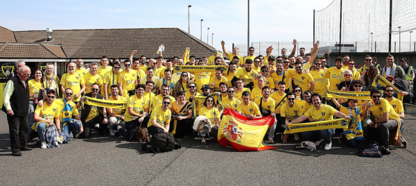 large group of football fans with u3a members wearing yellow t shirts