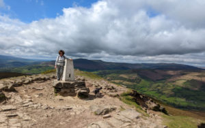 A woman standing at the peak of the Sugar Loaf Hill